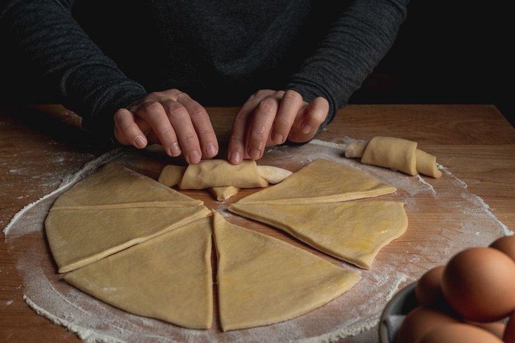 Pâtissier roulant la pâte pour croissants