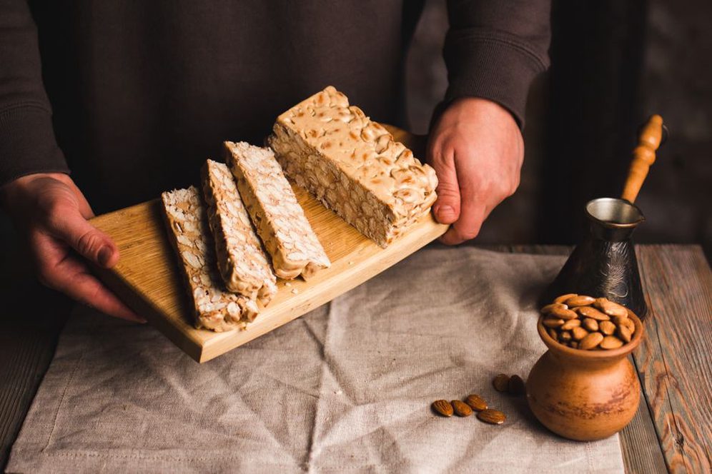 Des tranches révèlent les amandes dans le nougat blanc